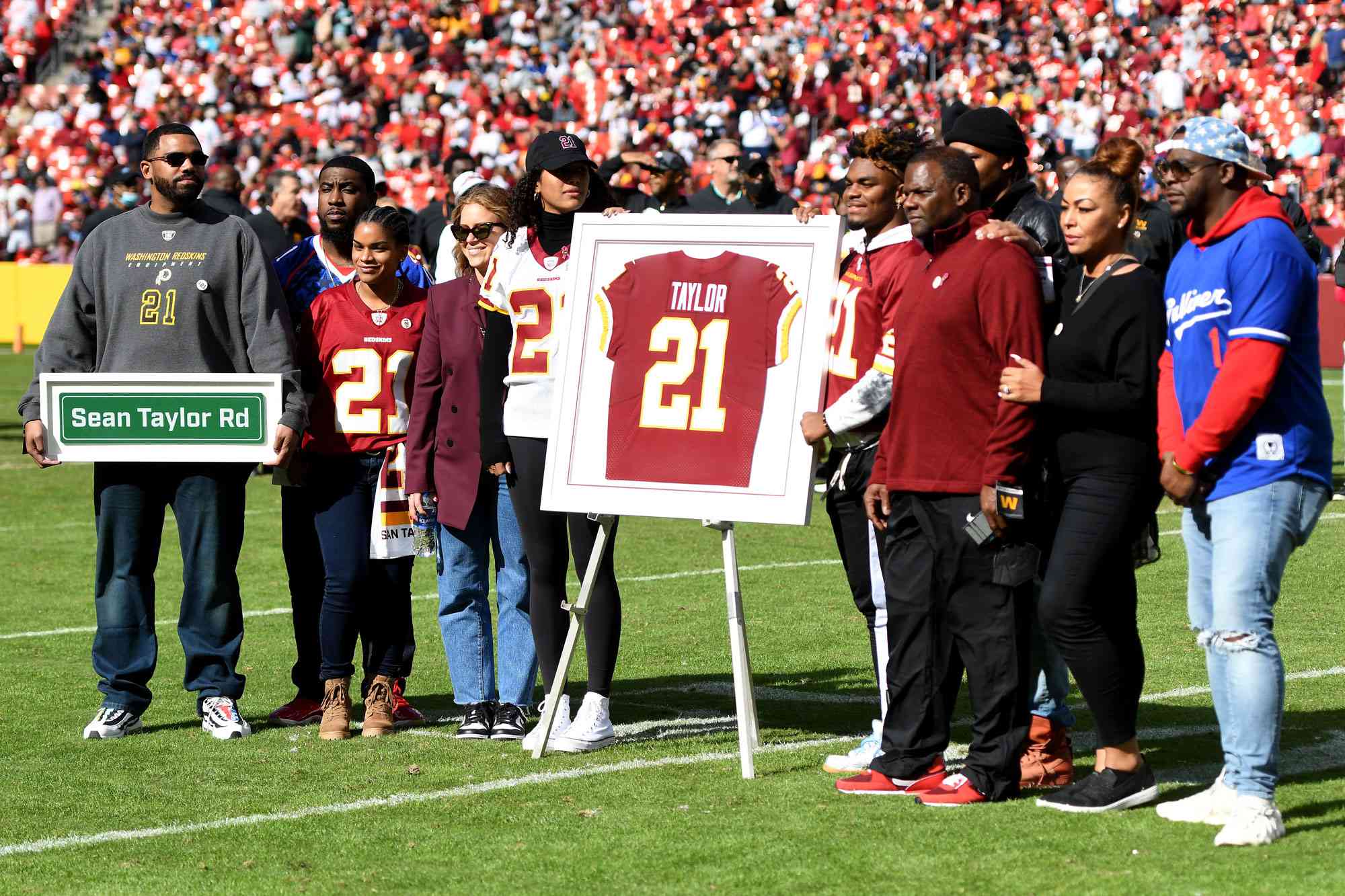 LANDOVER, MARYLAND - OCTOBER 17: Family and friends of Sean Taylor stand during the retirement ceremony of Taylor's jersey at FedExField on October 17, 2021 in Landover, Maryland. (Photo by Mitchell Layton/Getty Images)