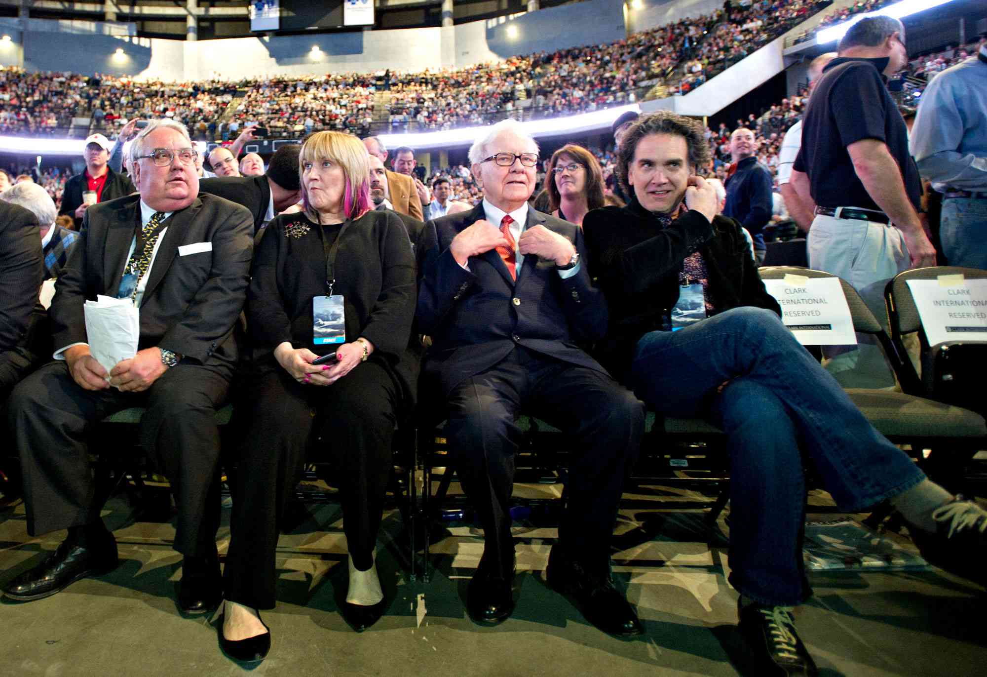 Warren Buffett, chairman of Berkshire Hathaway Inc., second from right, sits with his kids, from left, Howard, Susie and Peter on the floor of the Berkshire Hathaway shareholders meeting at the Qwest Center in Omaha, Nebraska, U.S., on Saturday, April 30, 2011