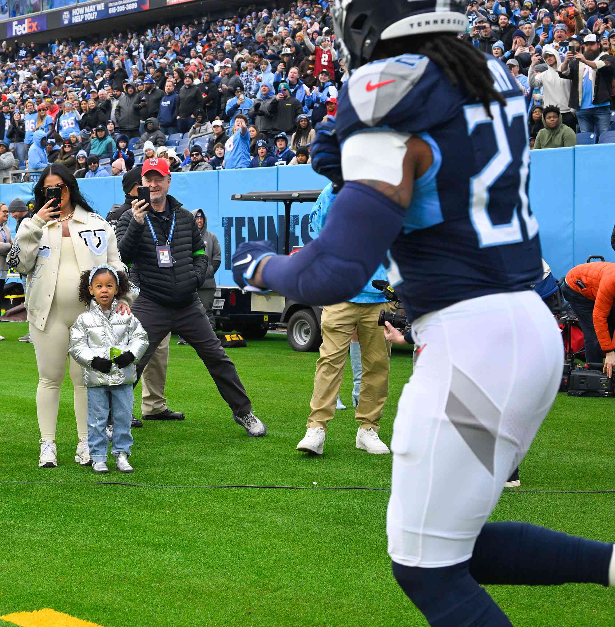 Tennessee Titans' Derrick Henry, looks toward his girlfriend Adrianna Rivas, second from right, and daughter Valentina Henry, next to her, as he is introduced onto the field before an NFL football game against the Jacksonville Jaguars Sunday, Jan. 7, 2024 in Nashville, Tenn. (AP Photo/John Amis)