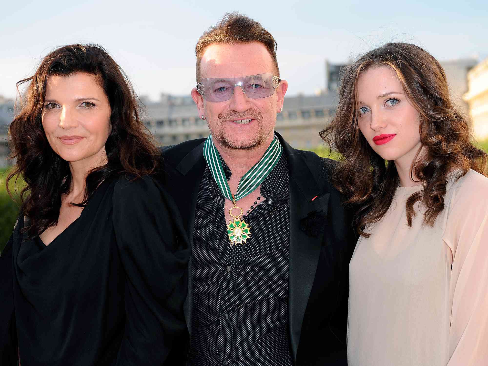 Bono (C) poses with his wife Ali Hewson (L) and daughter Hewson Jordan (R) at 'Commandeur de l'Ordre des Arts et Lettres' where Bono was honored at the Ministere de la Culture on July 16, 2013 in Paris, France