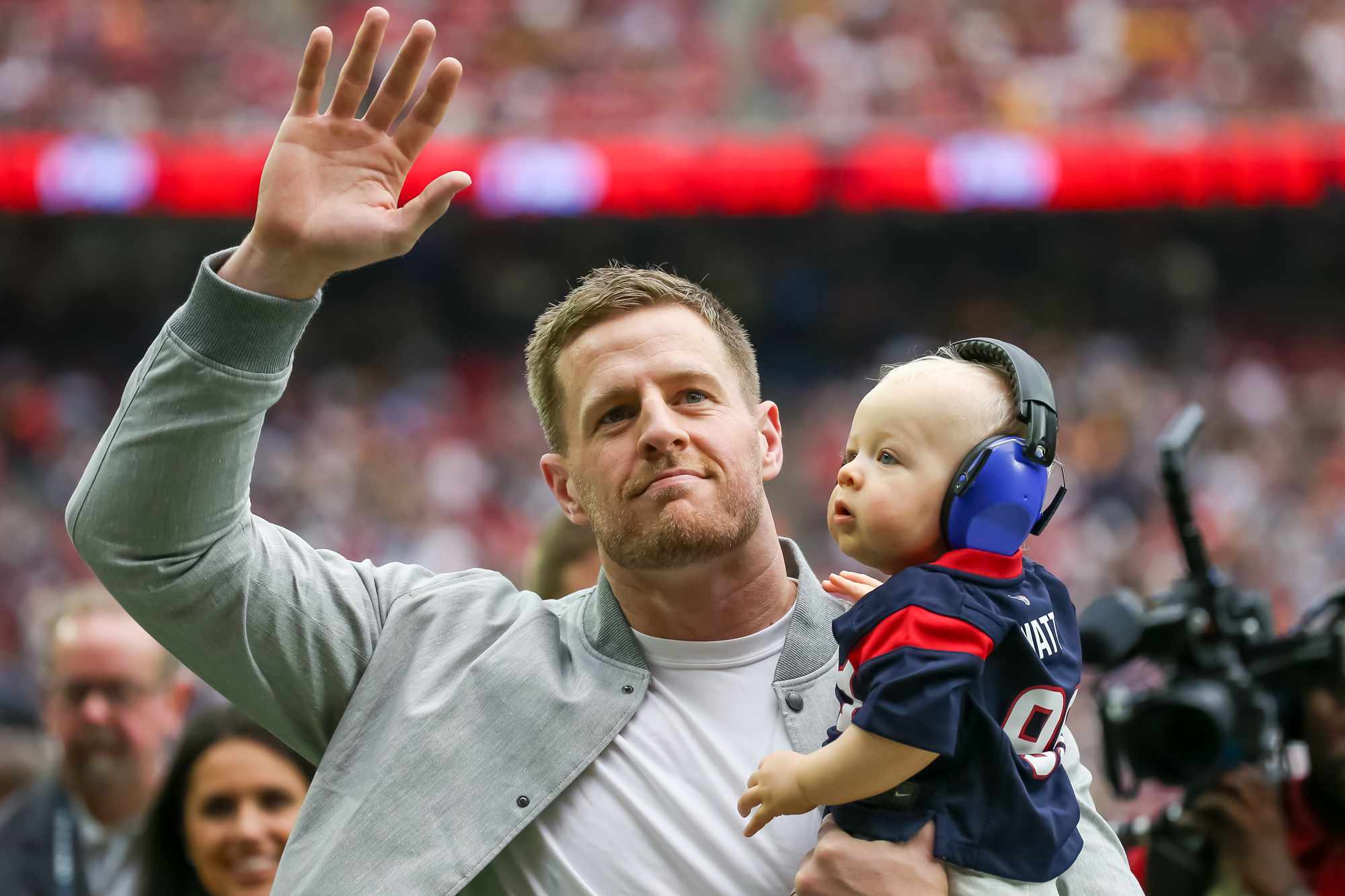 Former Houston Texans defensive end J.J. Watt waves to fans while holding his son Koa James during the NFL game between the Pittsburgh Steelers and Houston Texans on October 1, 2023 at NRG Stadium in Houston, Texas.