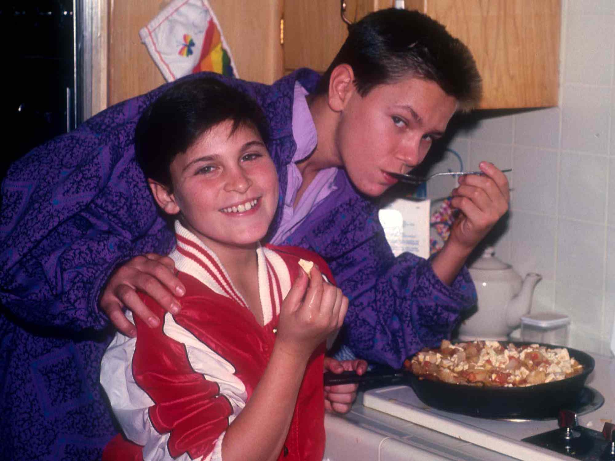 Joaquin and River Phoenix cooking at their home in Los Angeles, California, US, circa 1985