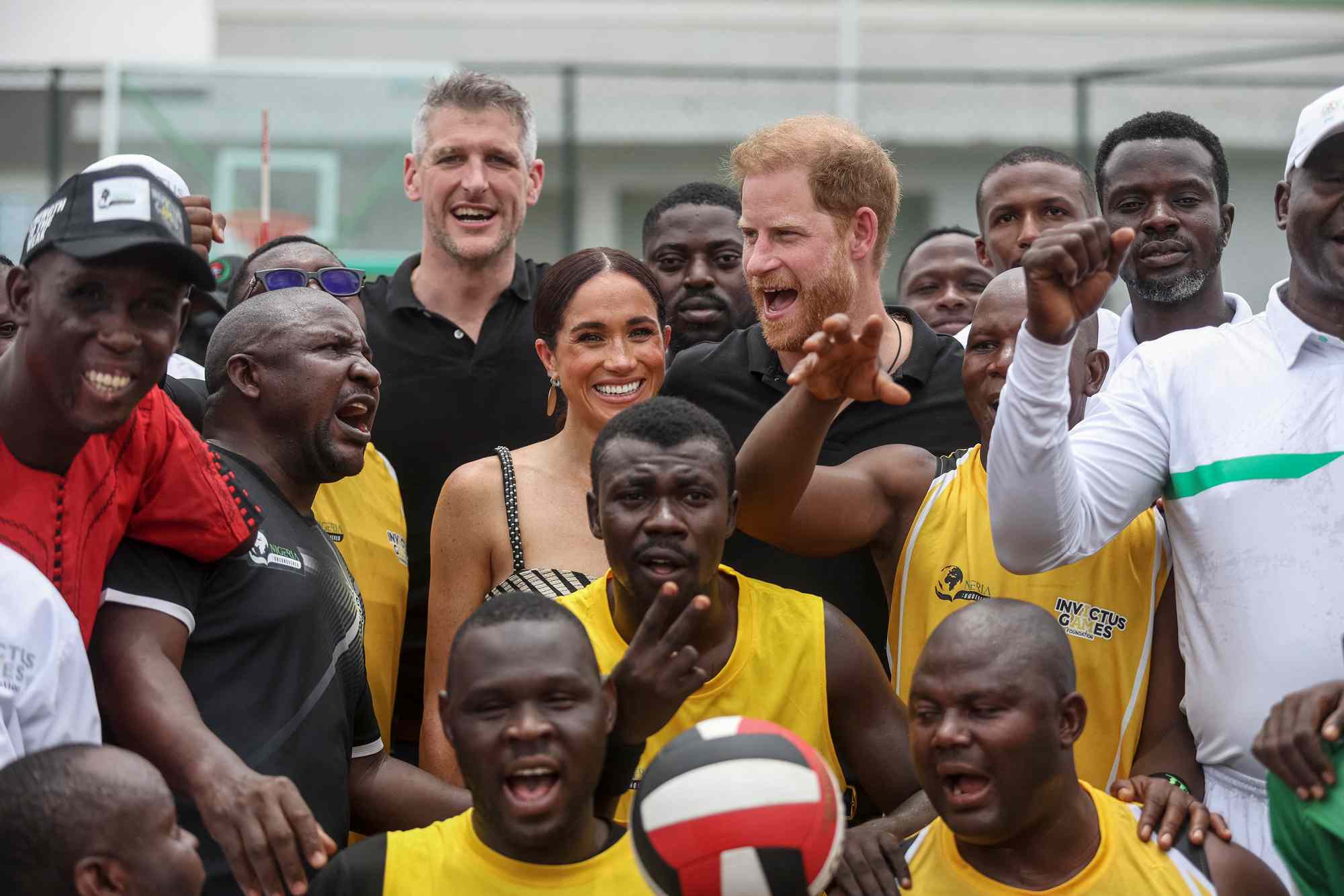 Britain's Prince Harry (CR), Duke of Sussex, and Britain's Meghan (CL), Duchess of Sussex, pose for a photographs with players ahead of an exhibition sitting volleyball match at Nigeria Unconquered, a local charity organisation that supports wounded, injured, or sick servicemembers, in Abuja on May 11, 2024 as they visit Nigeria as part of celebrations of Invictus Games anniversary. (