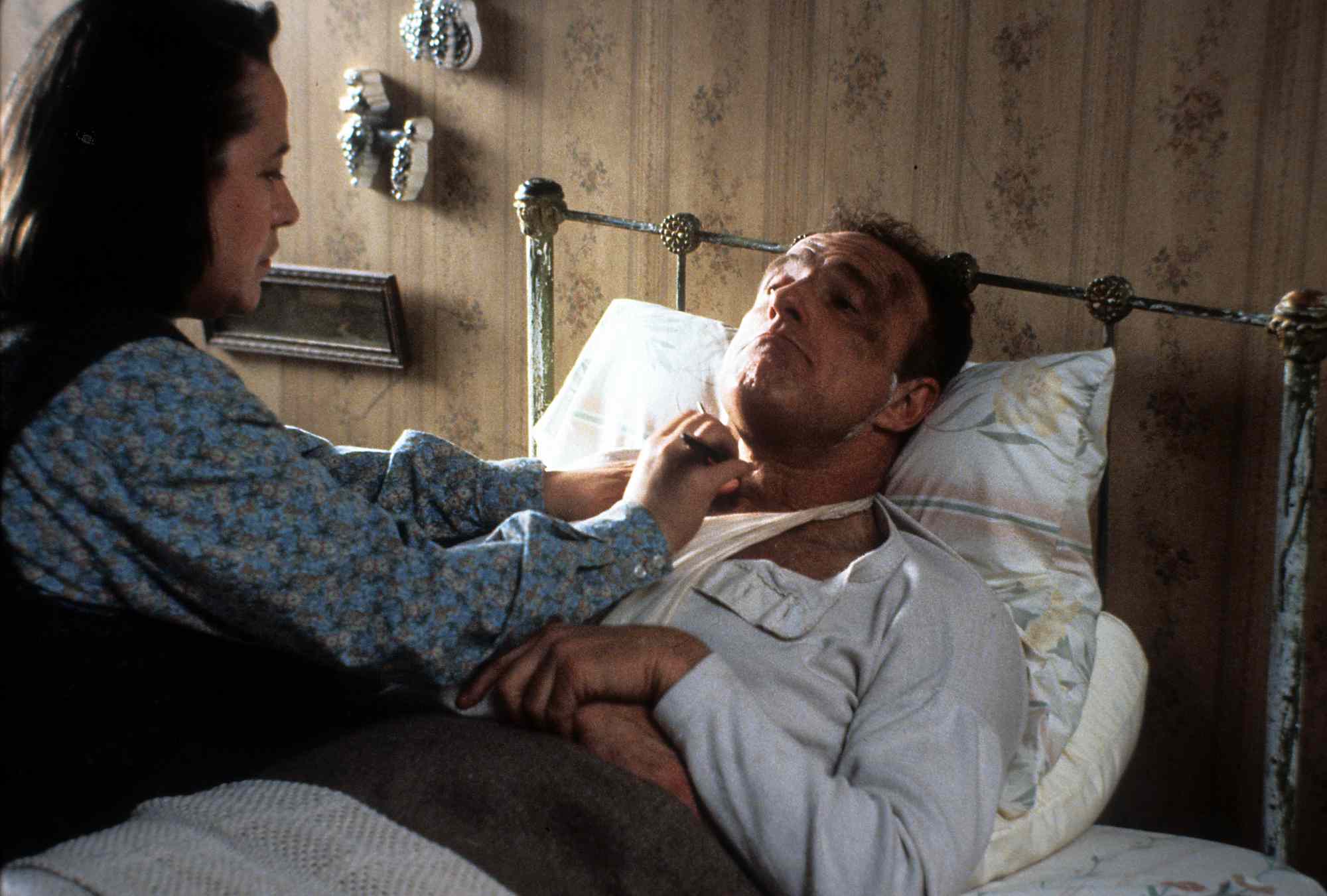 Kathy Bates watches over James Caan in a scene from the film 'Misery', 1990.