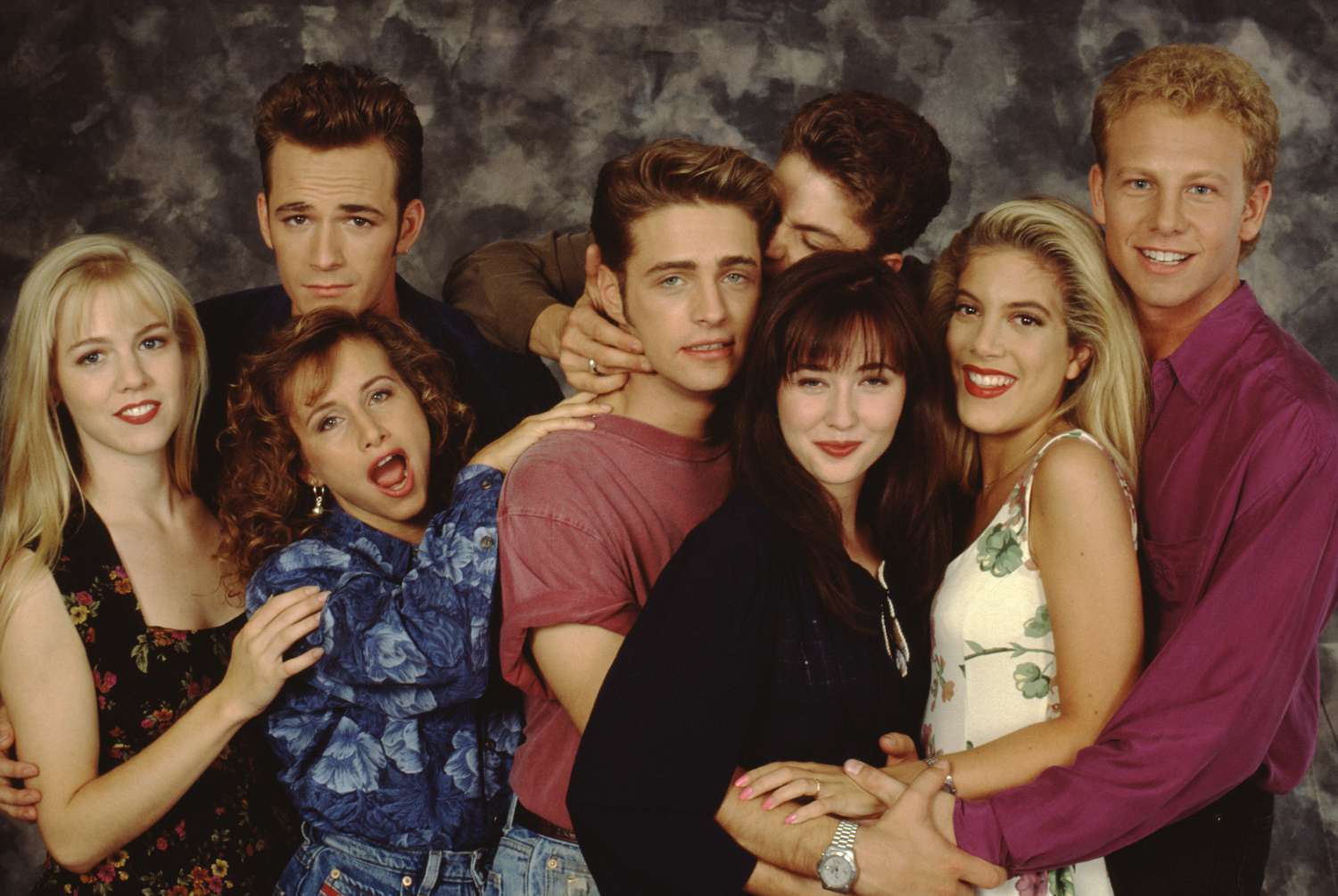 The Beverly Hills, 90210 cast poses for a portrait on set, September 1991 in Los Angeles, California. Left to right: Jennie Garth, Gabrielle Carteris, Luke Perry, Jason Priestley, Brian Austin Green, Shannen Doherty, Tori Spelling and Ian Ziering