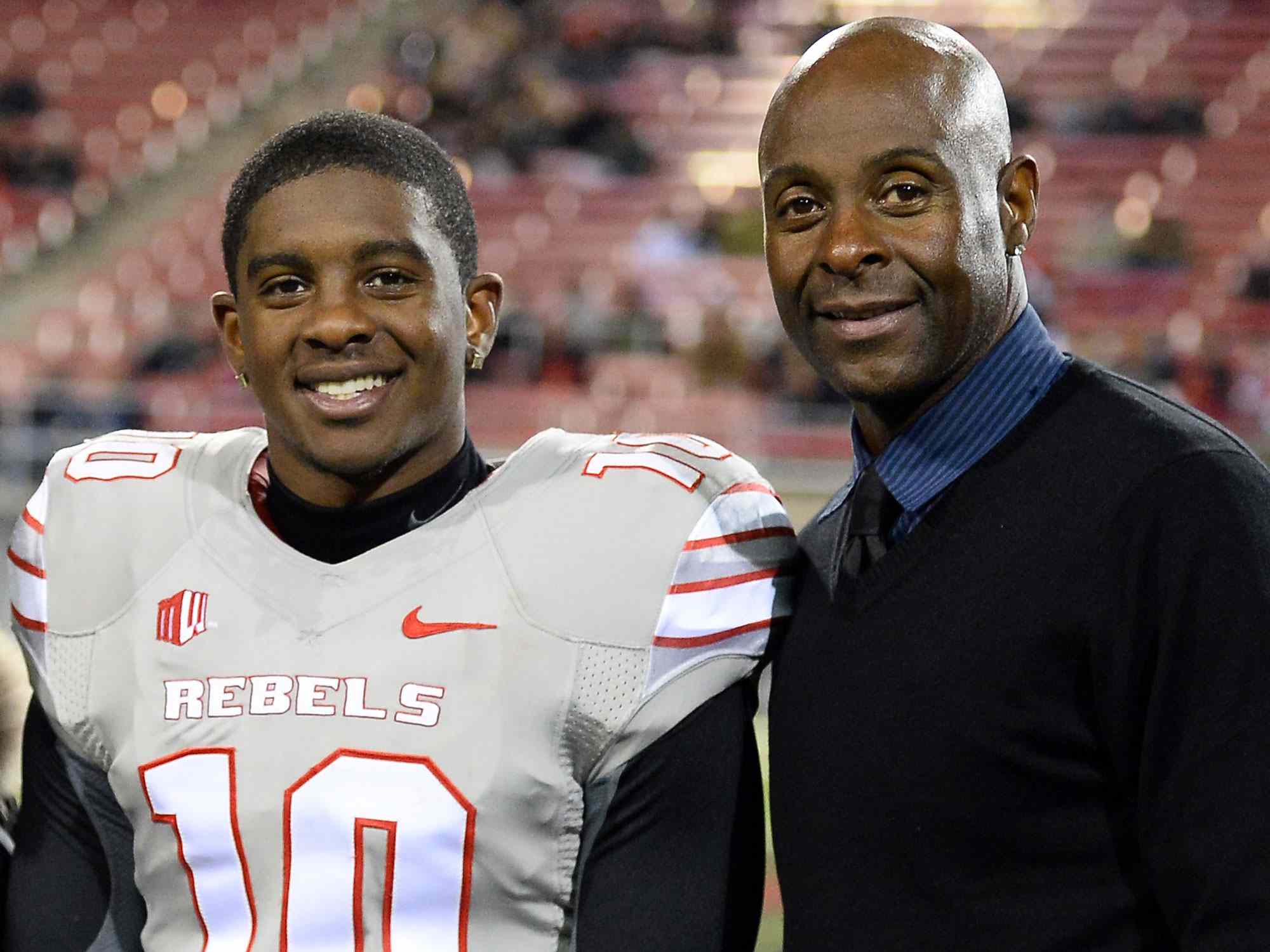 LAS VEGAS, NV - NOVEMBER 30: Jerry Rice Jr. #10 of the UNLV Rebels poses with his father, Hall of Fame National Football League player Jerry Rice, during senior night festivities on the field before UNLV's game against the San Diego State Aztecs at Sam Boyd Stadium on November 30, 2013 in Las Vegas, Nevada. (Photo by Ethan Miller/Getty Images)