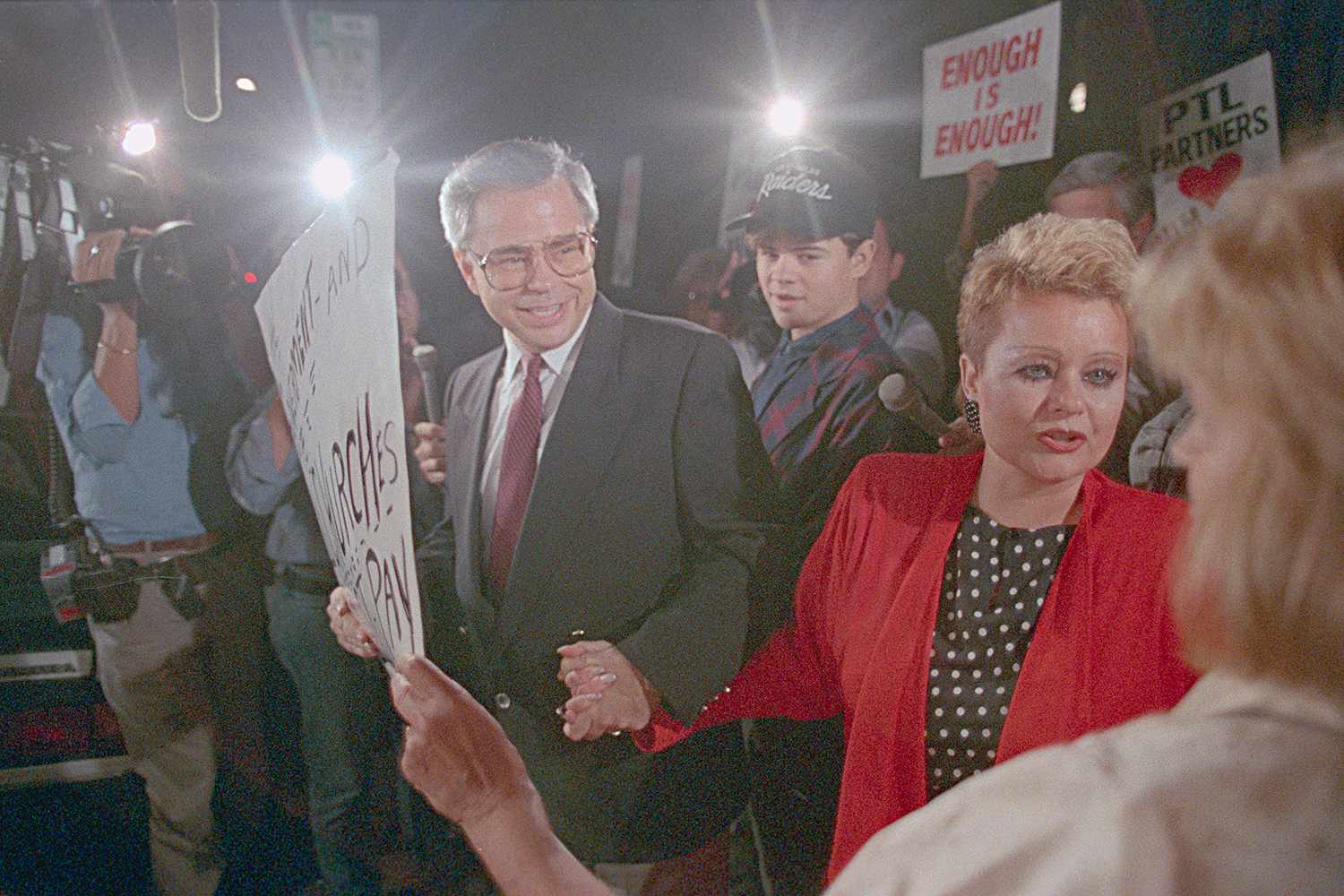 Jim Bakker, L, his son, Jamie, (C) and wife, Tammy Faye Bakker, greet supporters as they leave federal court in Charlotte. Bakker faces 120 years on 24 counts of fraud and conspiracy, as the case now is in the hands of the jury.