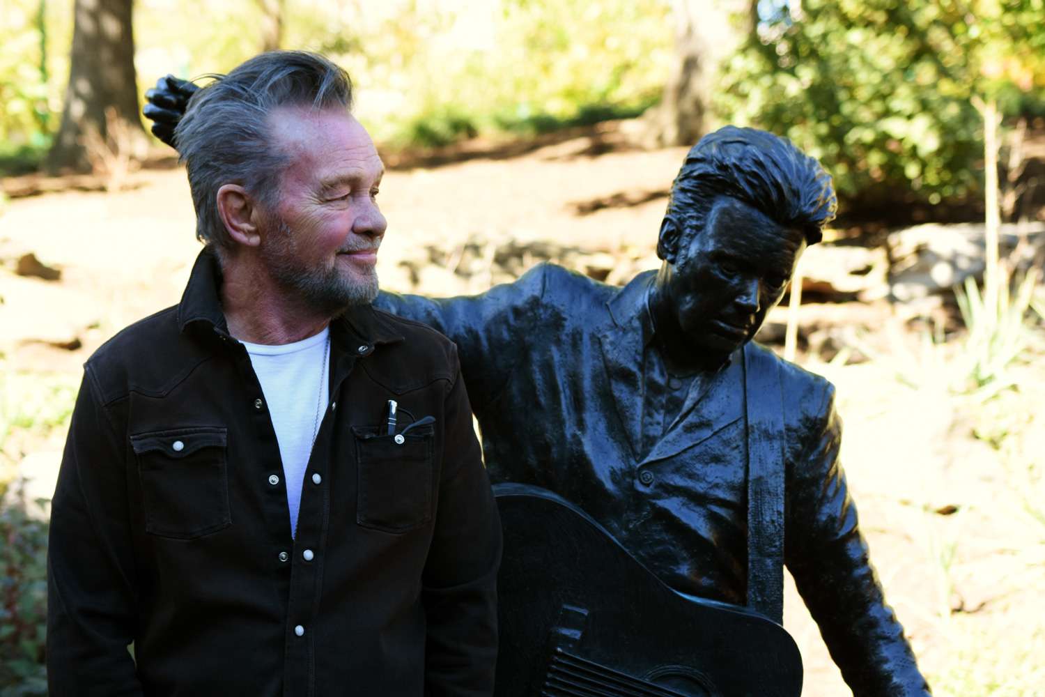 Musician, artist and activist John Mellencamp poses with his sculpture after an un