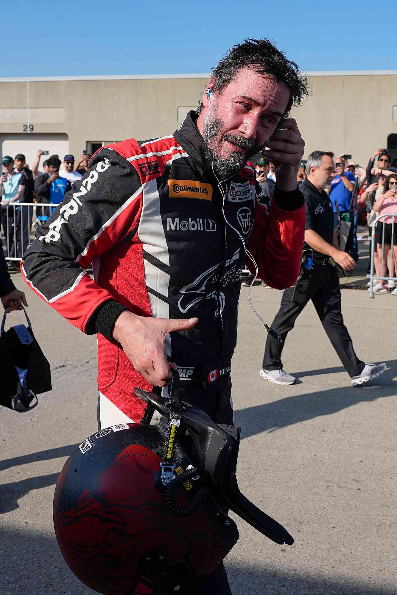 Keanu Reeves walks in the garage area following a GR Cup Series auto race at Indianapolis Motor Speedway, Saturday, Oct. 5, 2024, in Indianapolis. (AP Photo/Darron Cummings)