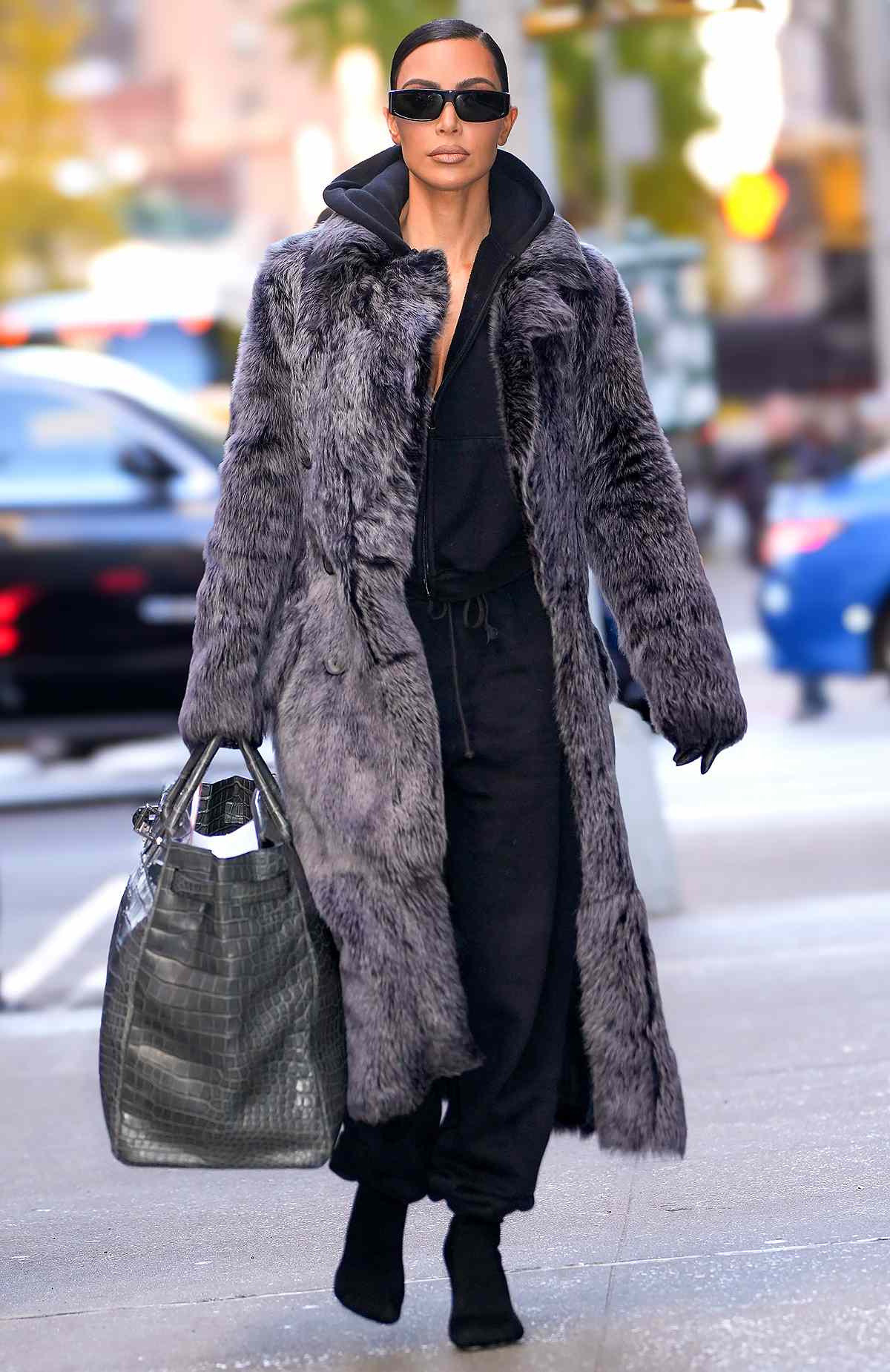 Kim Kardashian is seen going to business meetings in New York City. Kardashian carried a giant grey Hermes bag and wore a matching fur style trench coat, black hoodie, matching joggers, and heels.