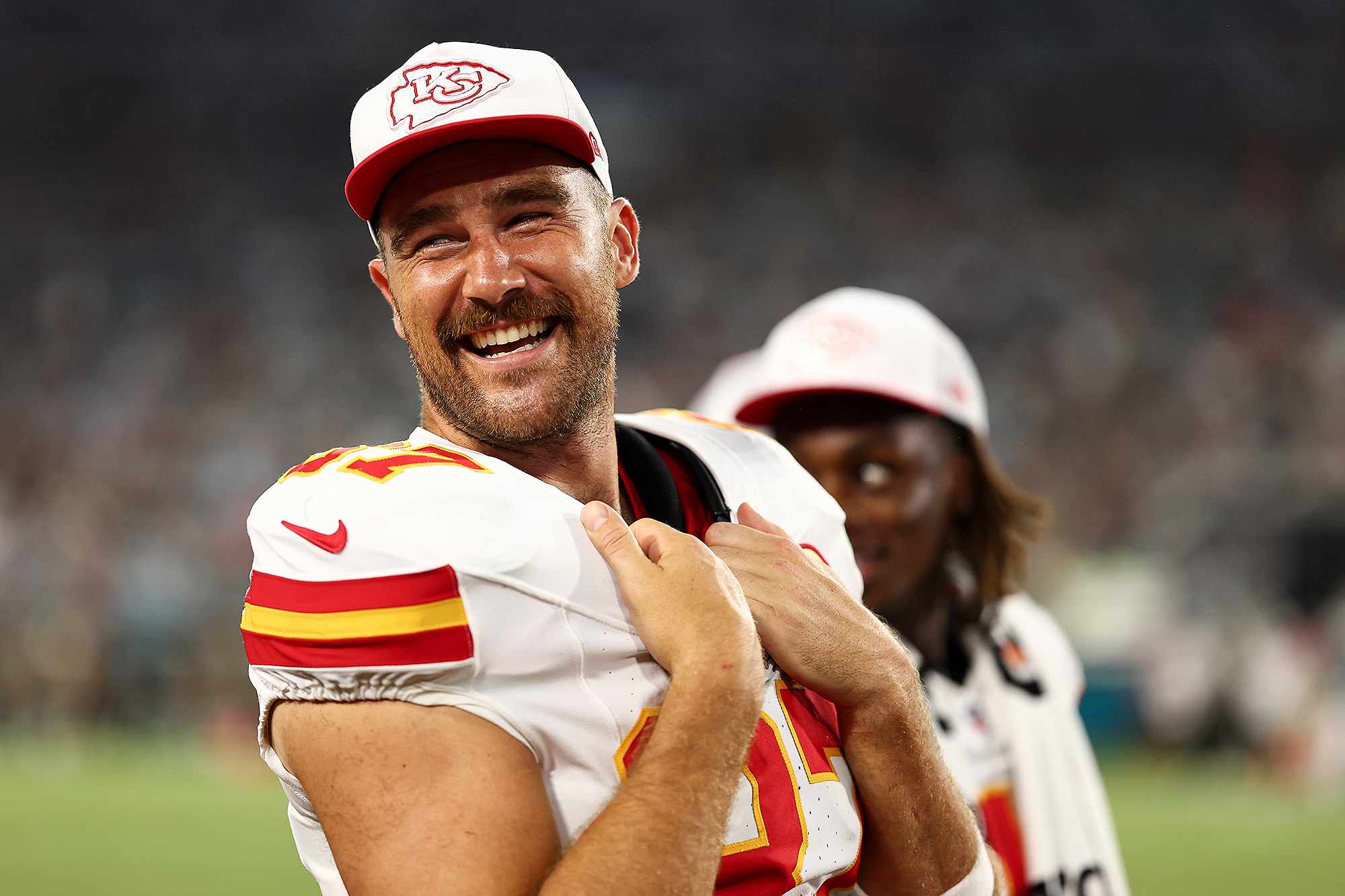 JACKSONVILLE, FL - AUGUST 10: Travis Kelce #87 of the Kansas City Chiefs smiles on the sidelines during the second quarter of an NFL preseason football game against the Jacksonville Jaguars at EverBank Stadium on August 10, 2024 in Jacksonville, Florida.