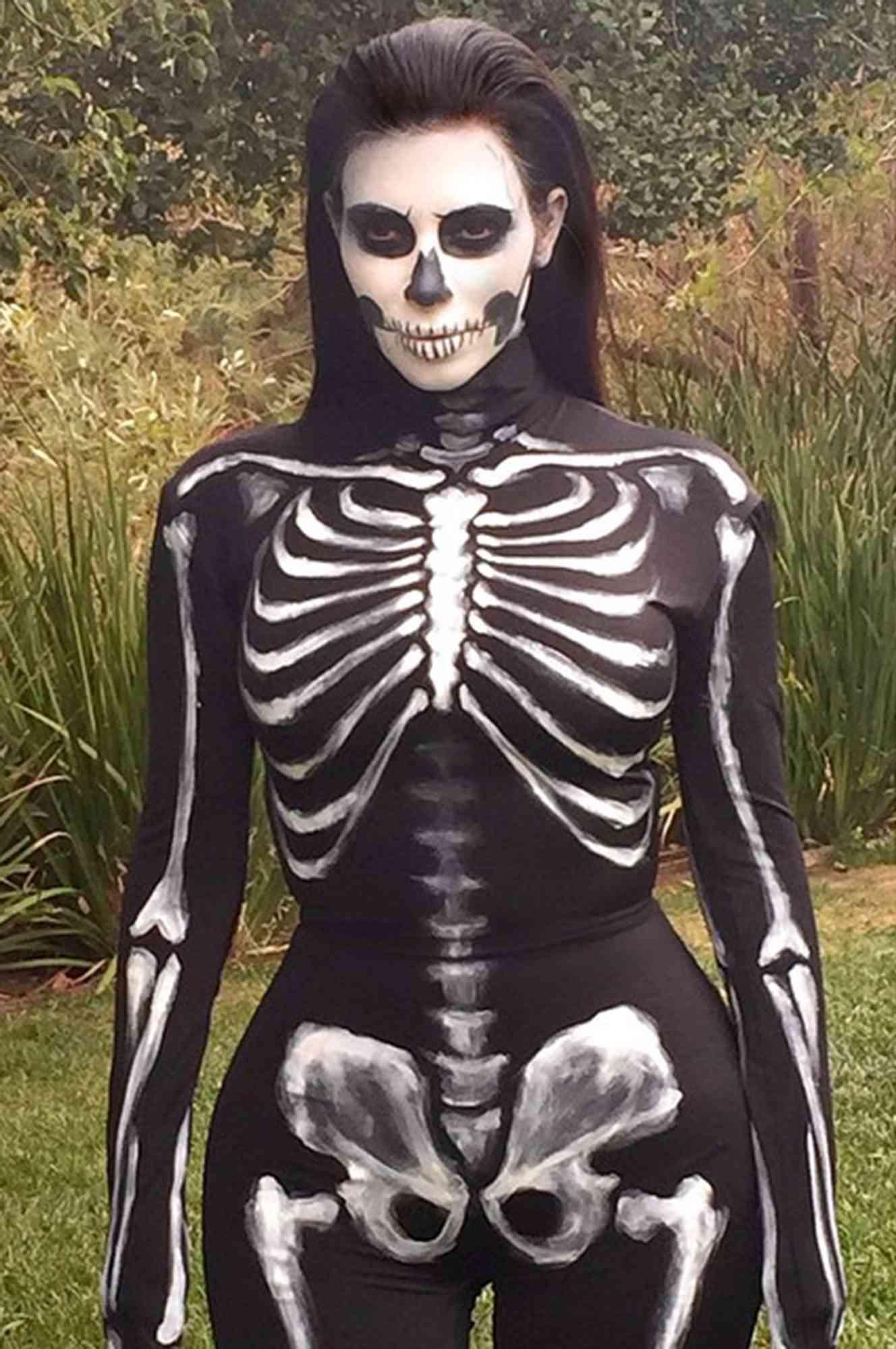 Kim Kardashian poses outside wearing skeleton makeup and a painted bodysuit in 2014