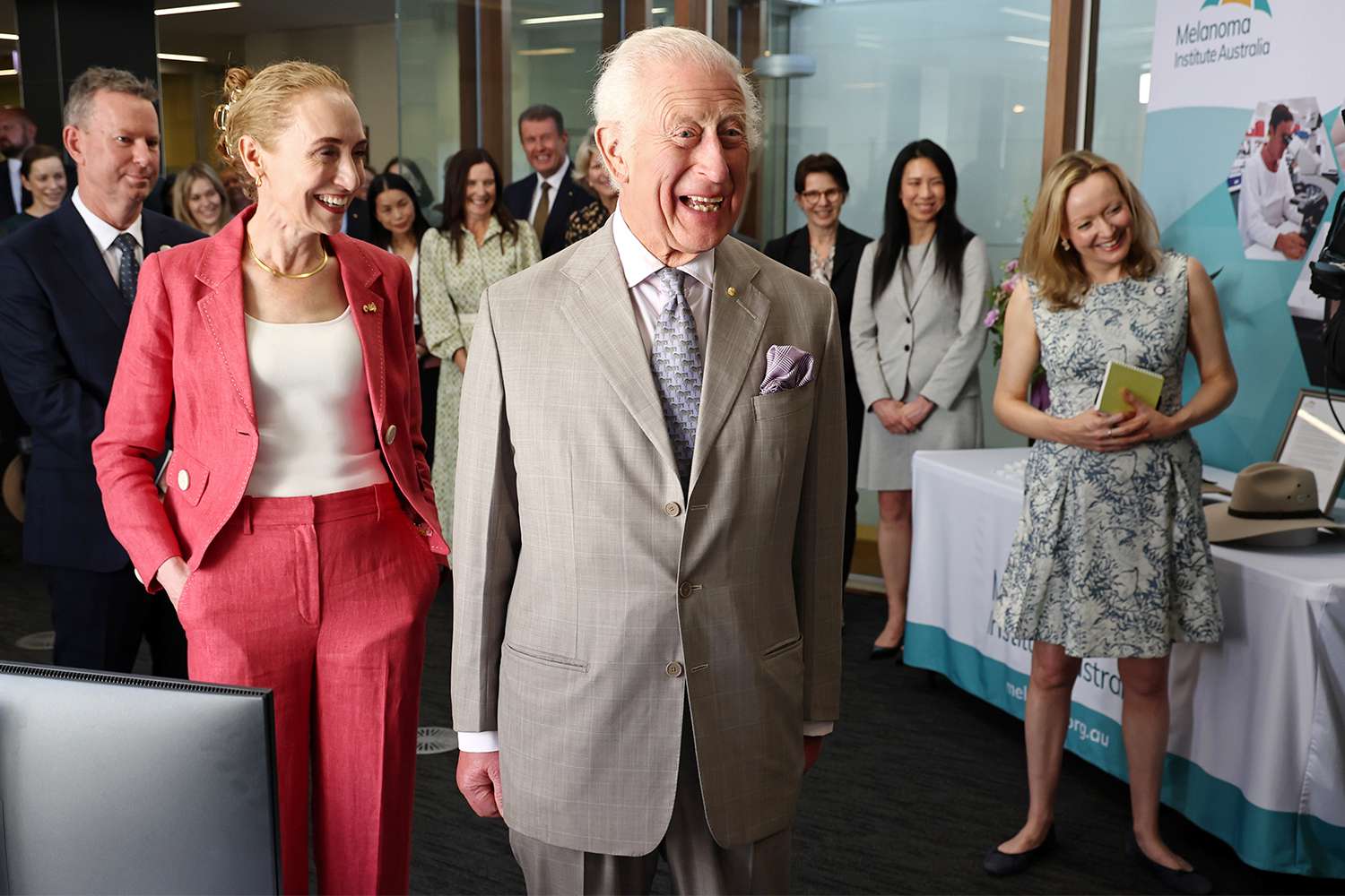 King Charles III reacts while co-medical director Georgina Long (2L) looks on during a visit to the Melanoma Institute of Australia on October 22, 2024 in Sydney, Australia. 