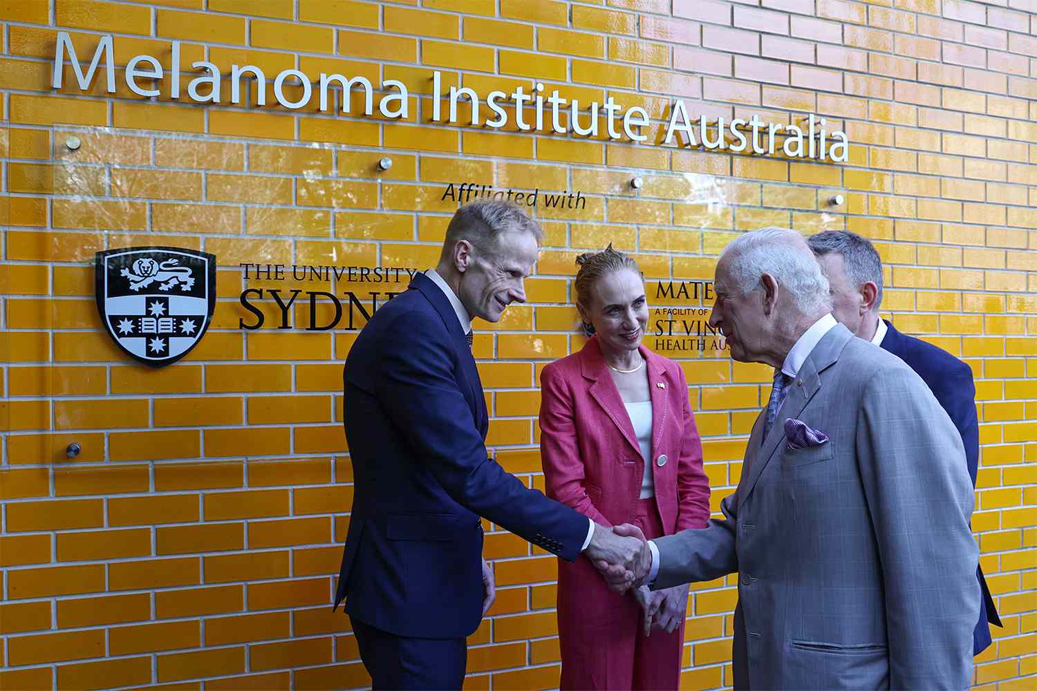 King Charles III (R) is greeted by co-medical directors Georgina Long (C) and Richard Scolyer (L) during a visit to the Melanoma Institute of Australia on October 22, 2024 in Sydney