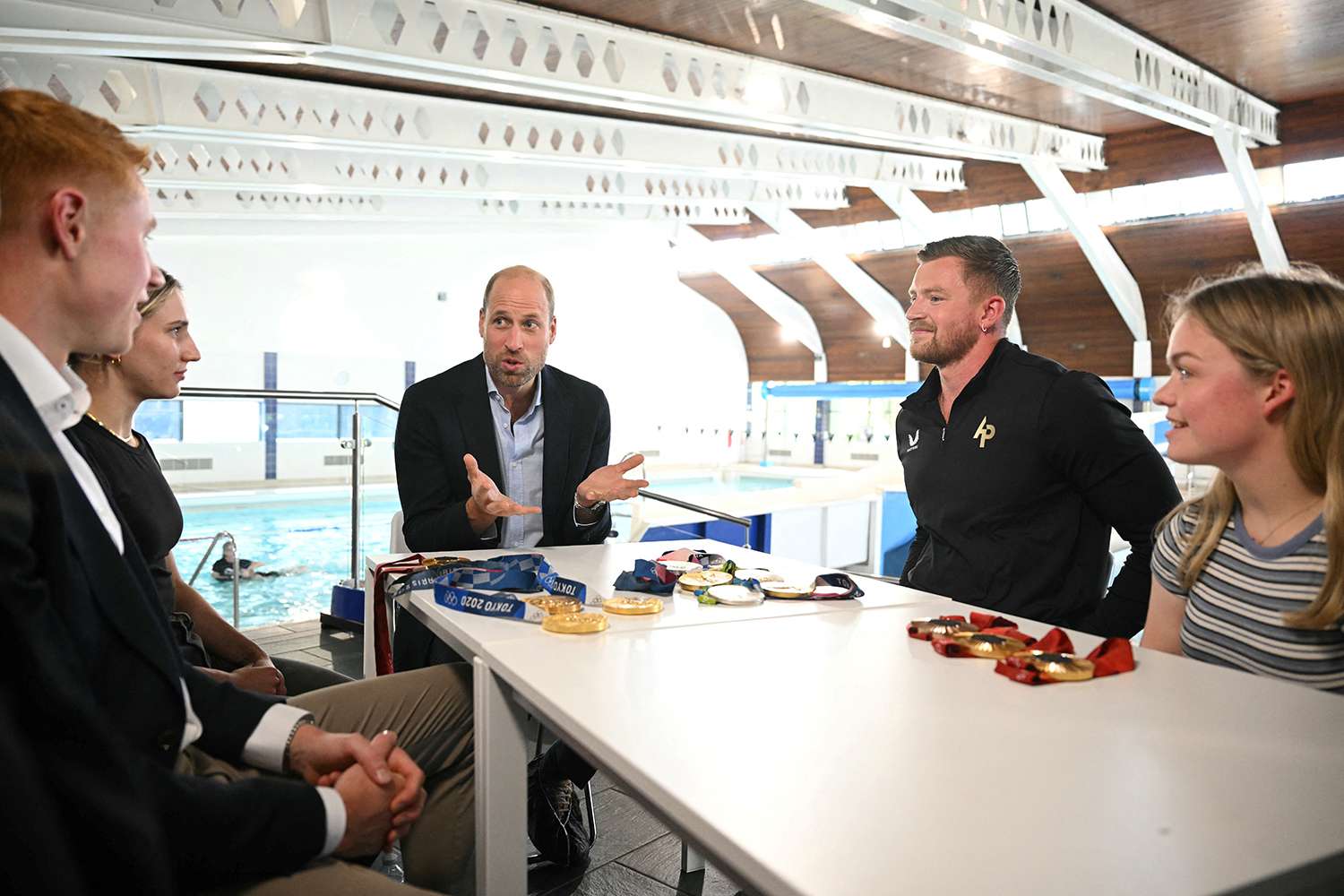 Prince William, Prince of Wales, speaks with British Olympians and Paralympians Adam Peaty (2ndR), Tom Dean (L), Maisie Summers-Newton (R) and Louise Fiddes (2ndL) during a visit to Birtley Community Pool in Tyne and Wear, northeast of England