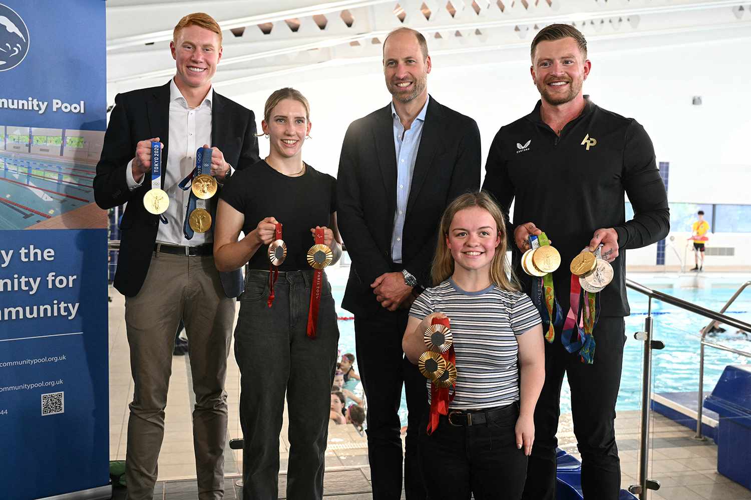 Prince William, Prince of Wales, poses for a picture with British Olympians and Paralympians Adam Peaty (R), Tom Dean (L), Maisie Summers-Newton (front R) and Louise Fiddes (2ndL) during a visit to Birtley Community Pool in Tyne and Wear, northeast of England,