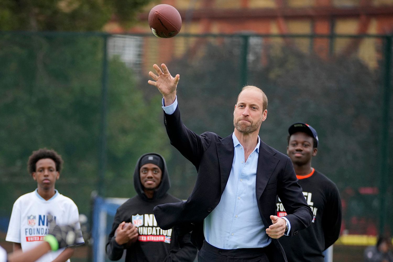 Britain's Prince William, Prince of Wales throws a football as he attends a NFL Foundation, flag football event, a non-contact form of American football, in London on Oct 15, 2024.