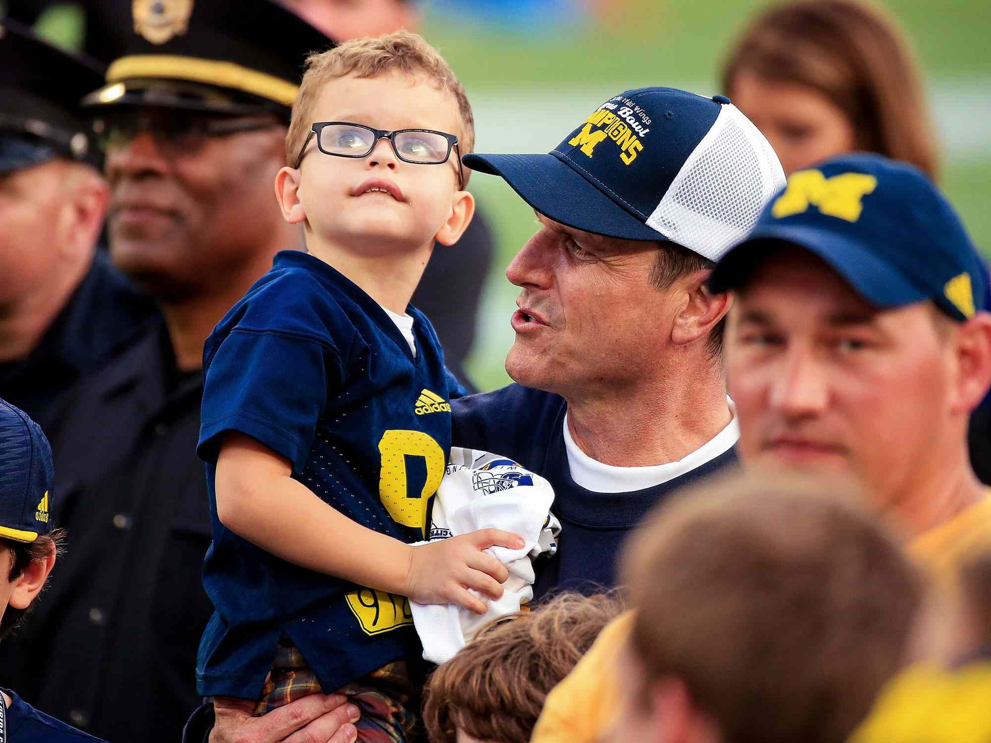 ORLANDO, FL - JANUARY 01: Head coach Jim Harbaugh of the Michigan Wolverines holds his son Jack Harbaugh after the Buffalo Wild Wings Citrus Bowl game against the Florida Gators at the Orlando Citrus Bowl on January 1, 2016 in Orlando, Florida. (Photo by Rob Foldy/Getty Images)