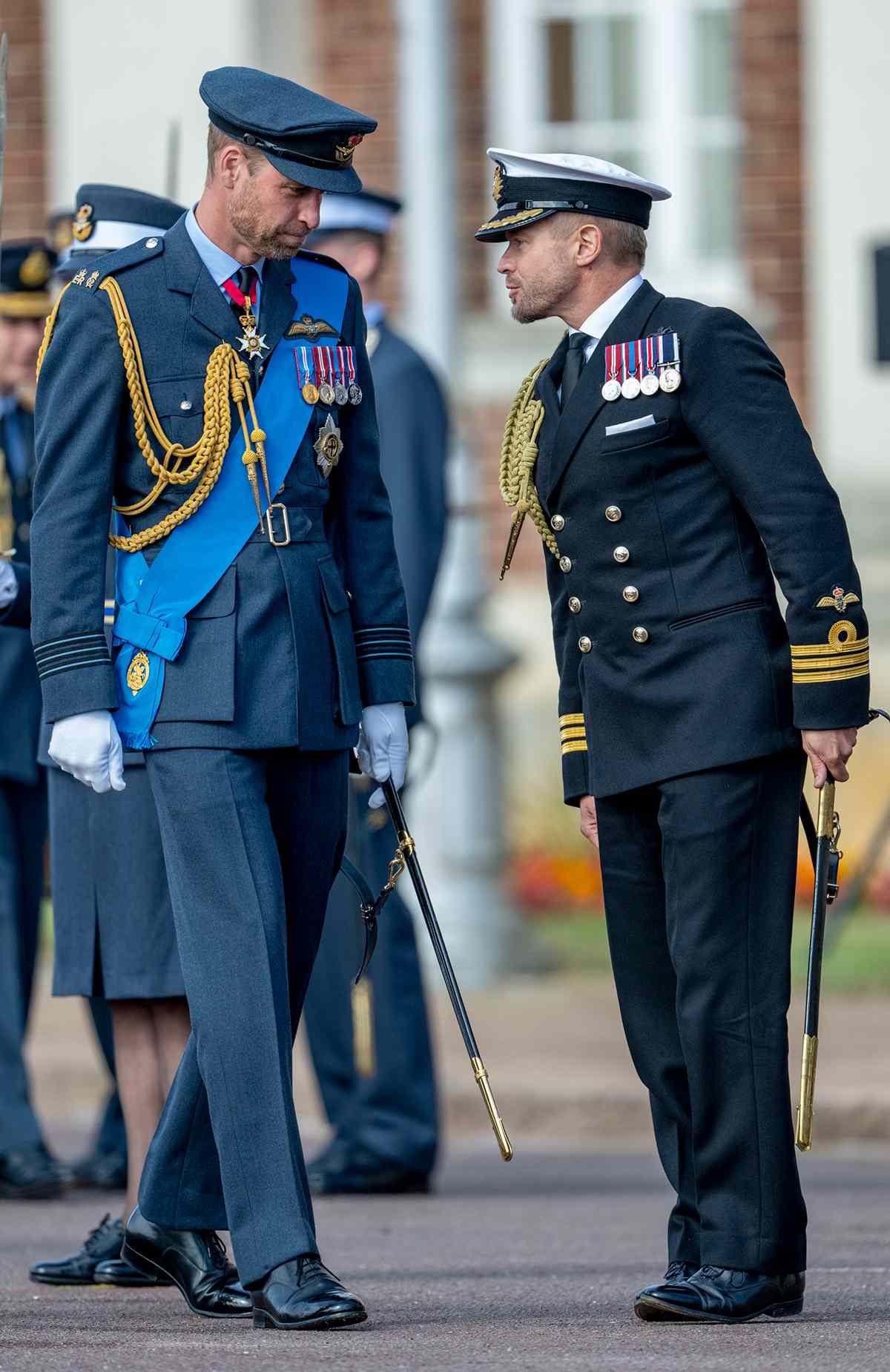 Prince William, Prince of Wales with Commander Rob Dixon (Equerry to Prince William, Prince of Wales and Catherine, Princess of Wales) attend the Sovereign's Parade on behalf of King Charles III at the Royal Air Force College in Cranwell on September 12, 2024 in Sleaford, England. The parade features 48 Royal Air Force cadets and 4 international officer cadets from Jordan, Kenya, Pakistan, and Uganda, graduating from the commissioned warrant officers course and modular initial officer training.