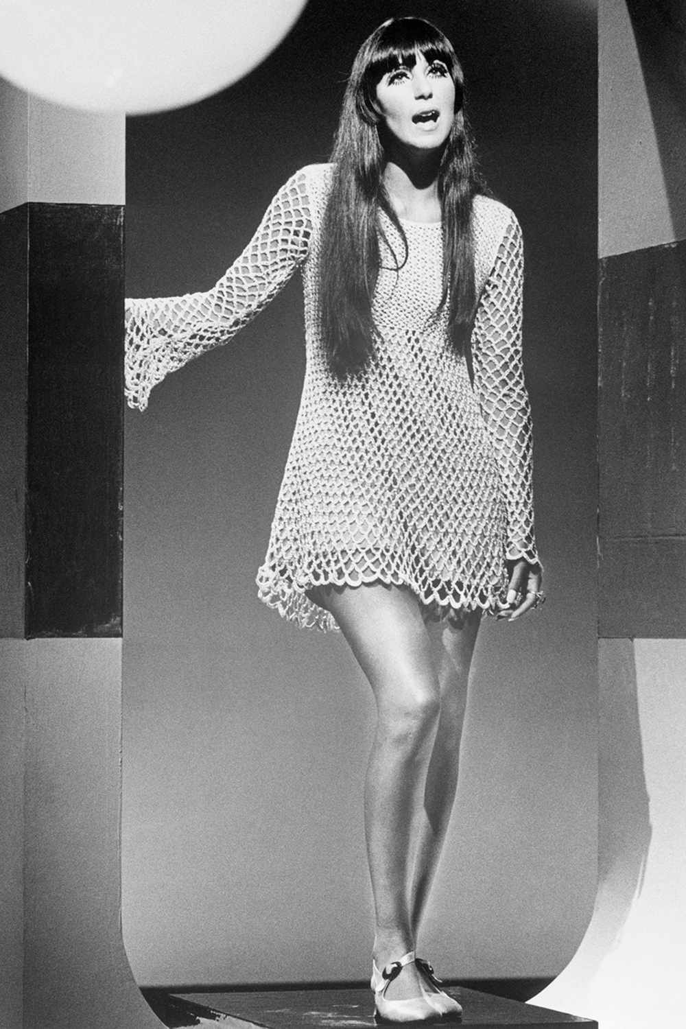 -Cher Bono, of Sonny & Cher, performing during a TV guest appearance. She is shown full length, wearing a crocheted mini-dress.