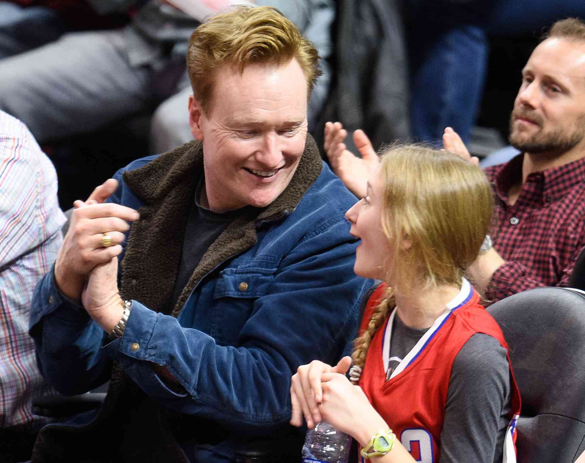 Conan O'Brien and his daughter Neve O'Brien attend a basketball game between the Houston Rockets and the Los Angeles Clippers on January 18, 2016 in Los Angeles, California. 