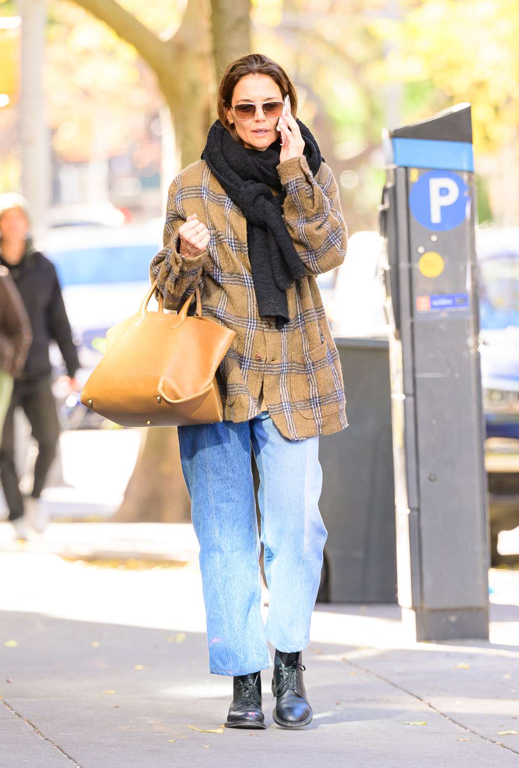 Katie Holmes is spotted stepping out in New York City. The American actress was dressed casually in tan plaid jacket with a black scarf denim jeans, black boots and a Khaite envelope pleat tote.