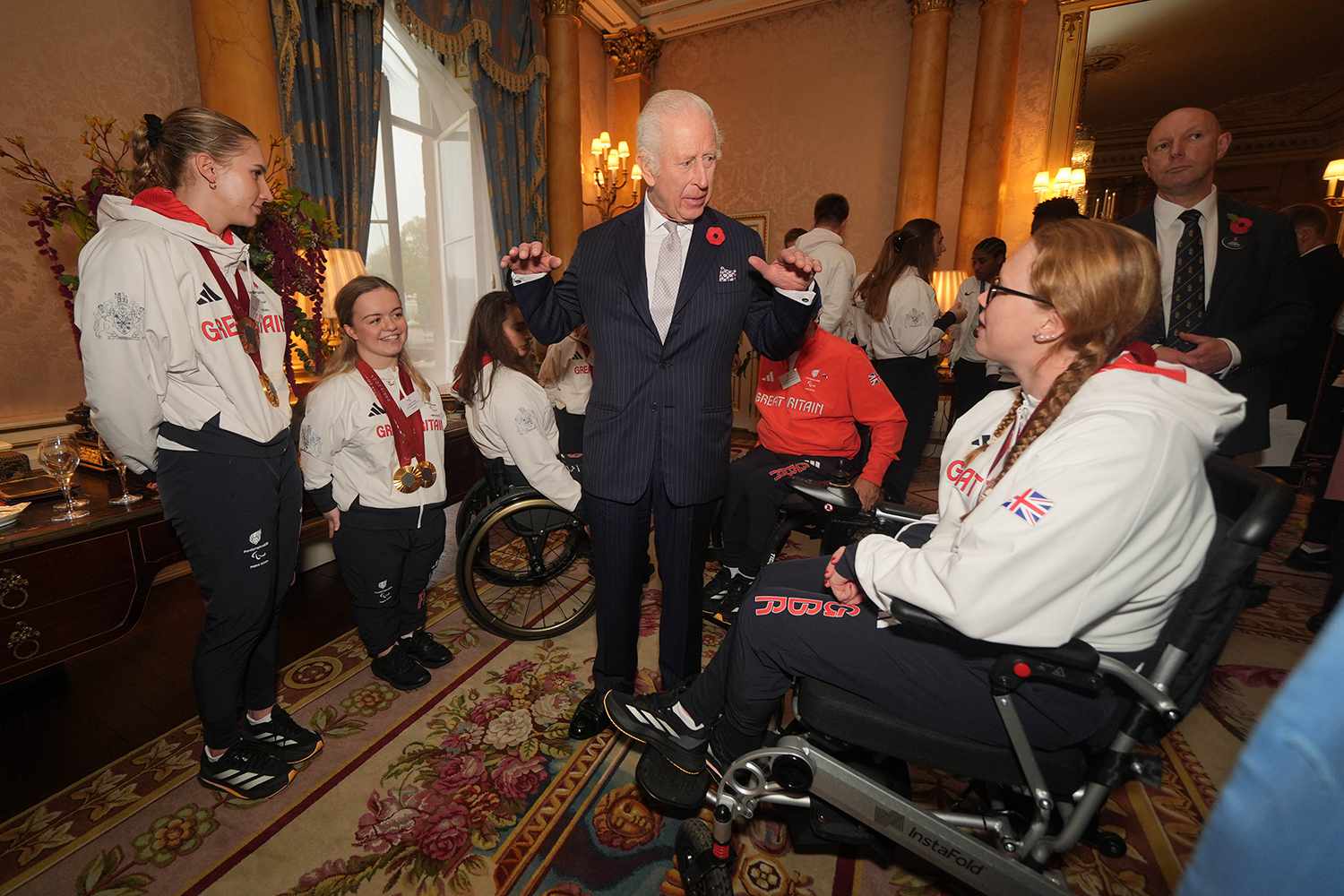 King Charles III speaks with guests during a reception for medalists from the Paris 2024 Olympic and Paralympic Games at Buckingham Palace