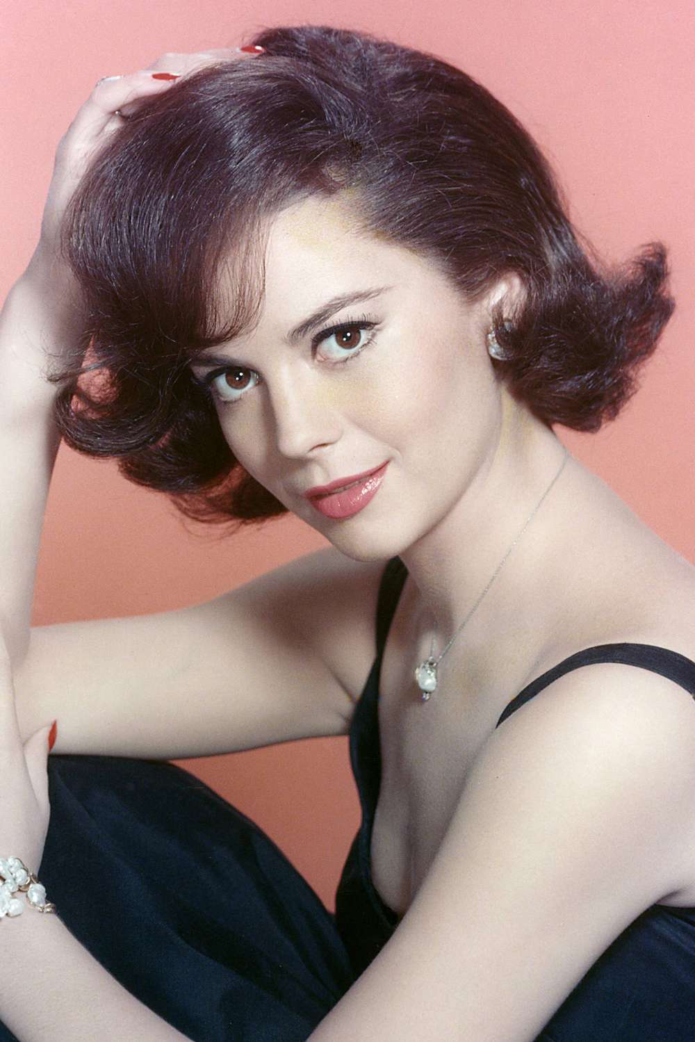 Natalie Wood in a studio portrait, against a pink background, circa 1965.