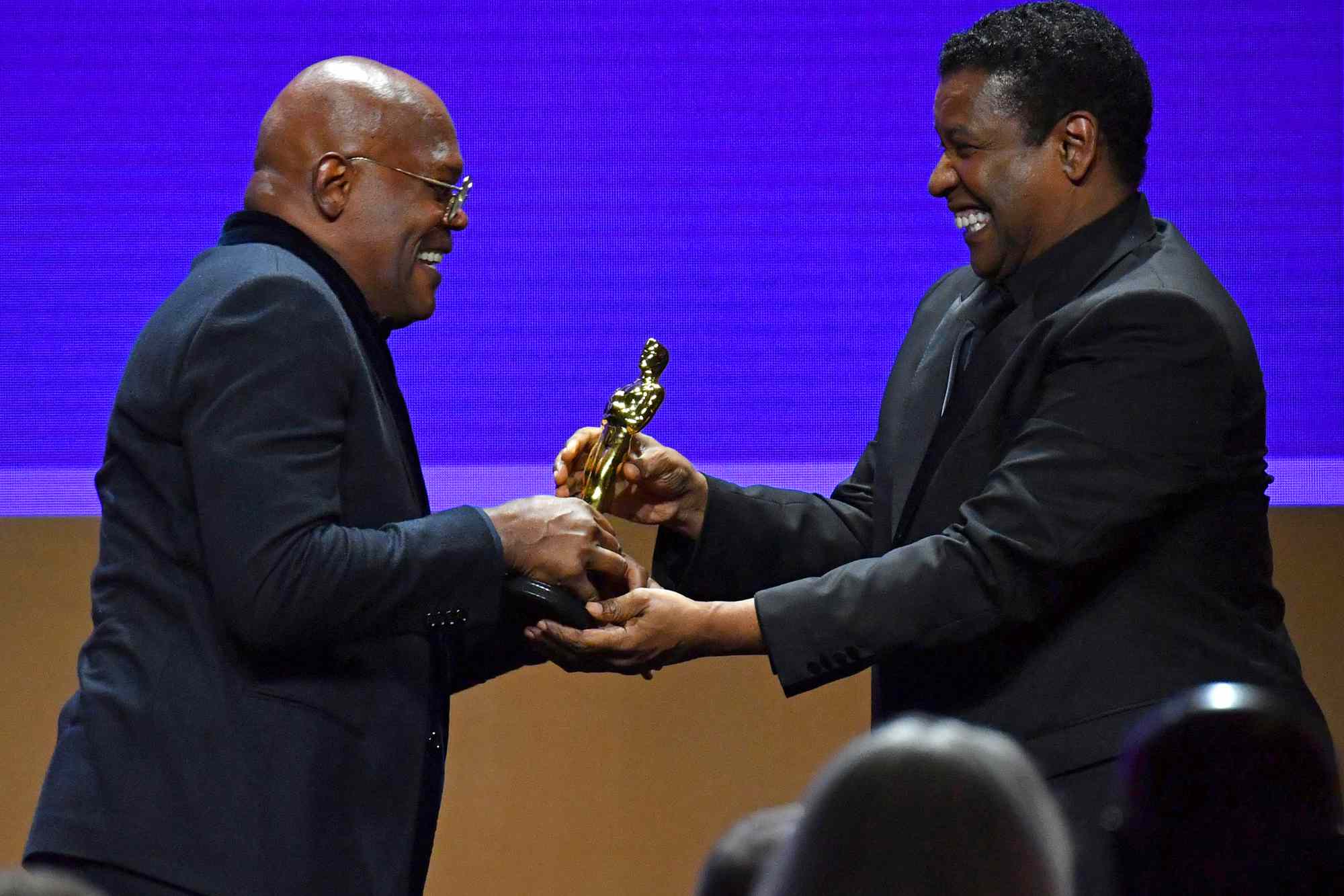 Denzel Washington presents US actor Samuel L Jackson with an honorary Oscar onstage during the Academy Of Motion Picture Arts And Sciences' 12th Annual Governors Awards at the Ray Dolby Ballroom at Hollywood & Highland Center in Hollywood, California on March 25, 2022.