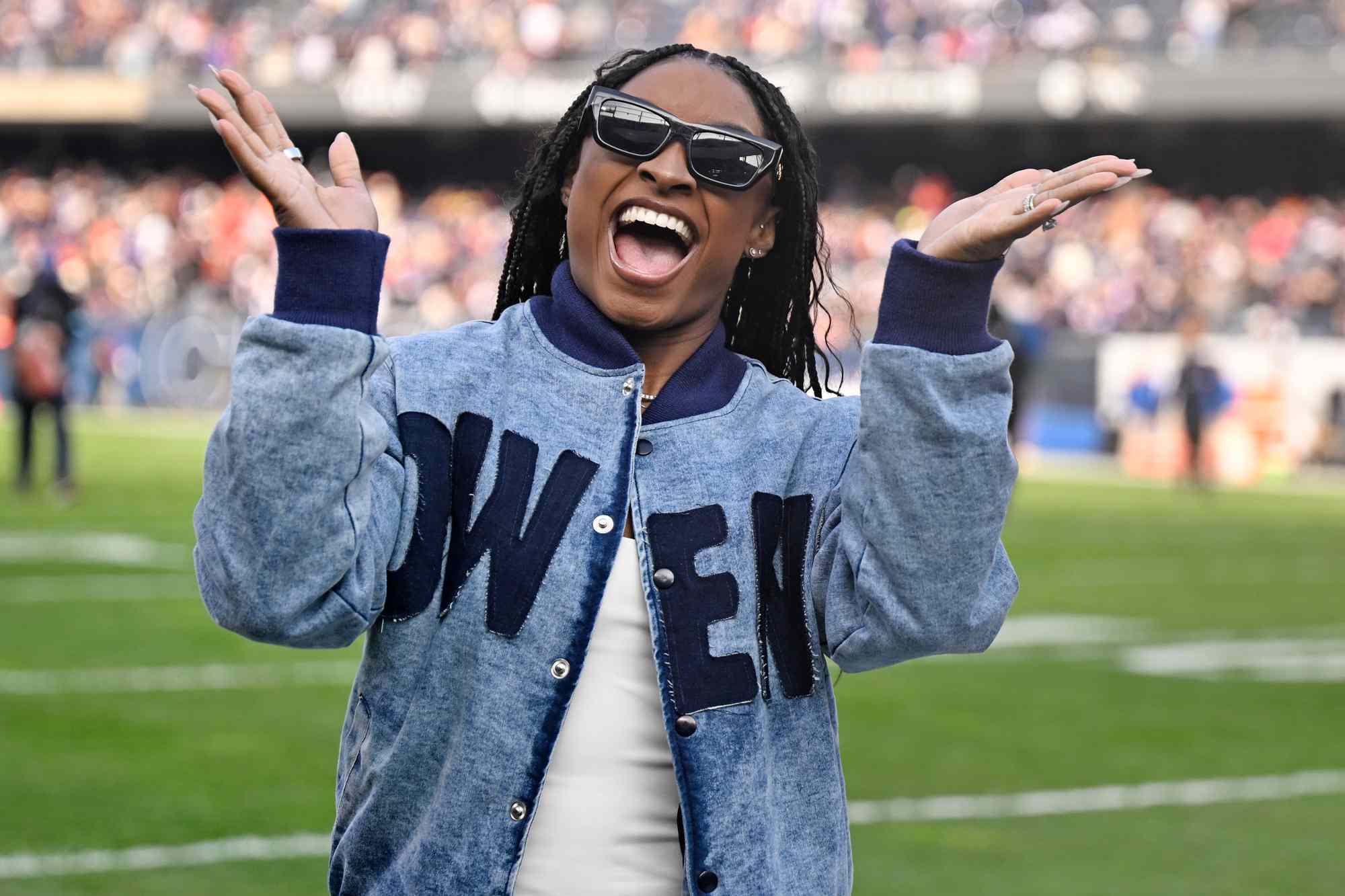 Simone Biles waves to the crowd during halftime of a game between the Chicago Bears and the Minnesota Vikings at Soldier Field on November 24, 2024 in Chicago, Illinois.