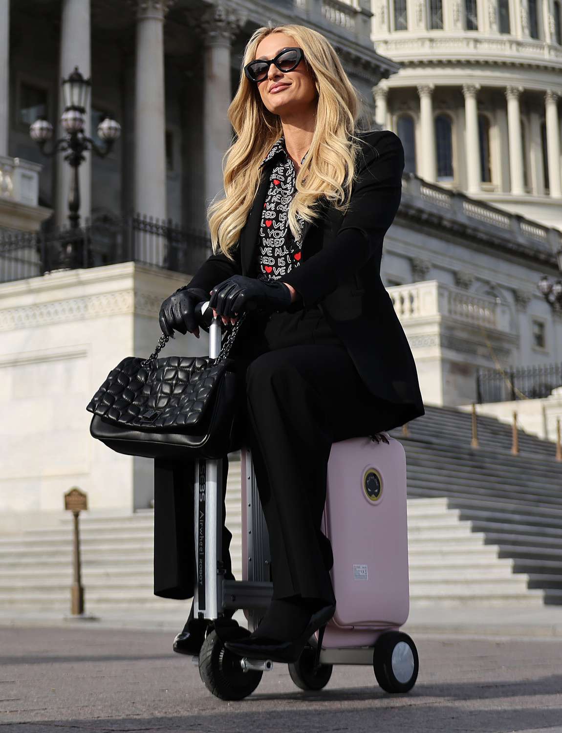 Paris Hilton is photographed by a member of her team as she rides an Airwheel electric