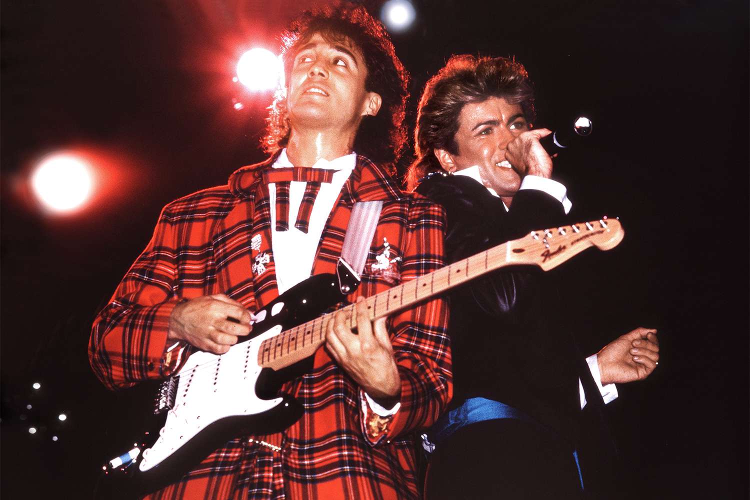 Andrew Ridgeley and George Michael of Wham! perform on stage in London, 1984