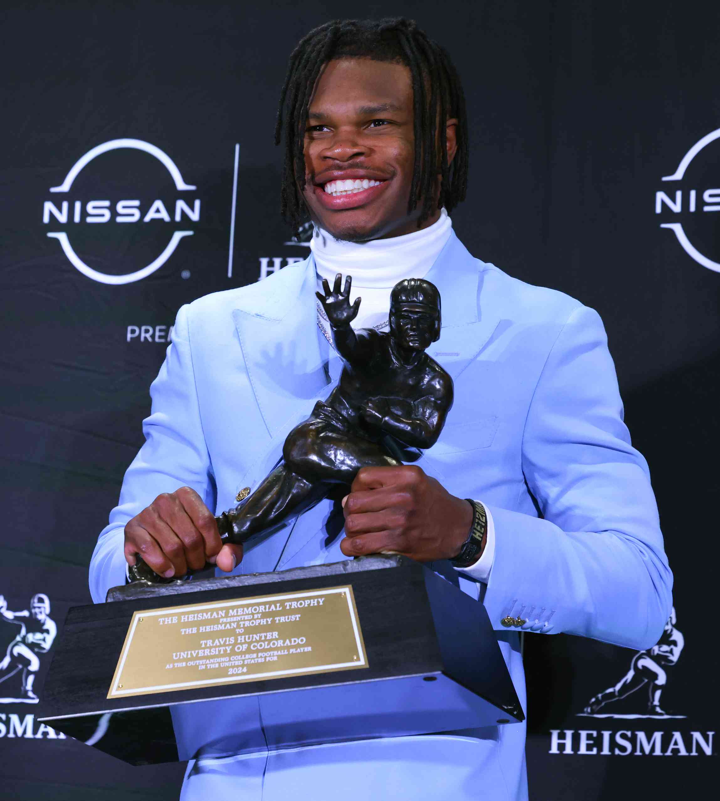 Travis Hunter University of Colorado cornerback/wide receiver poses with the Trophy during the Heisman Trophy press conference at the Marriott Marquis on December 14, 2024 in New York, New York.