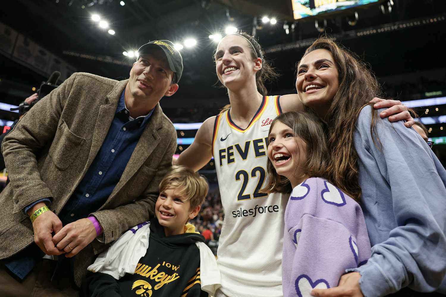 Caitlin Clark #22 of the Indiana Fever poses for a photo with Ashton Kutcher and Mila Kunis after defeating the Los Angeles Sparks at Crypto.com Arena