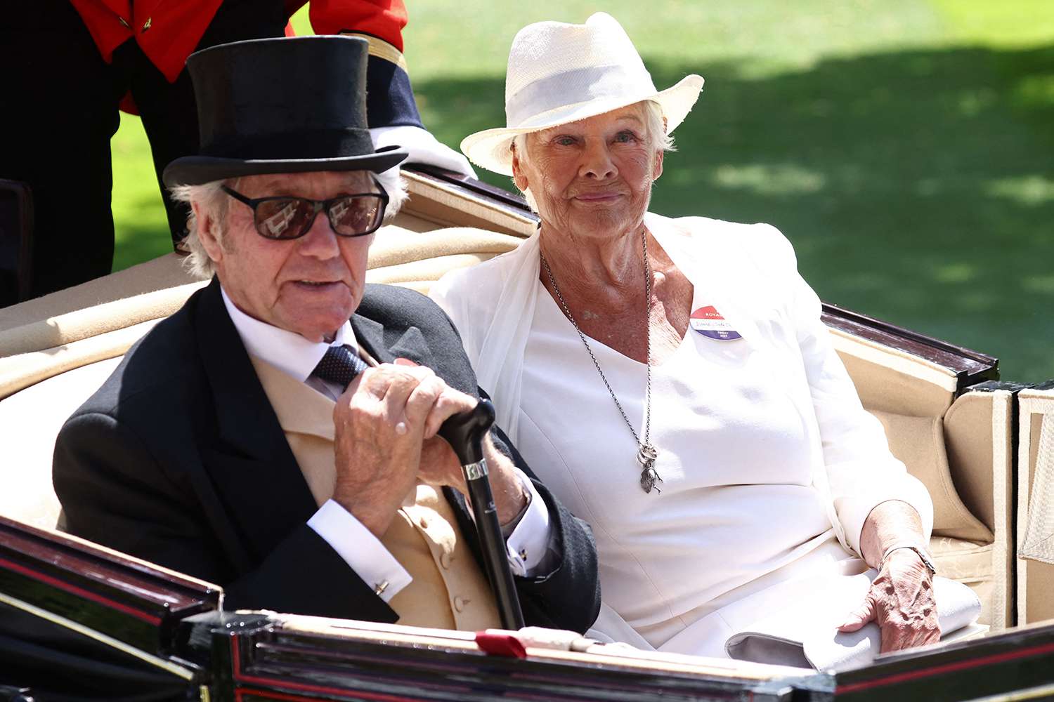 Judi Dench (R) and her partner David Mills (L) arrive in a horse-drawn carriage, part of the Royal Procession on the fourth day of the Royal Ascot horse racing meeting in Ascot