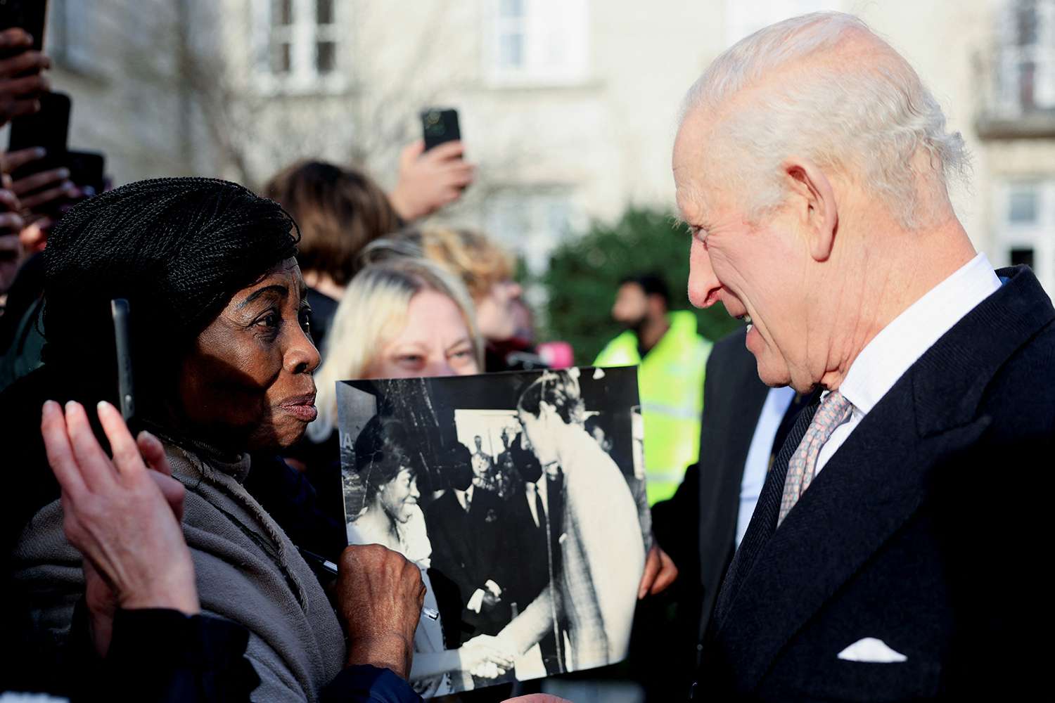 Caroline Akuffo shows King Charles III an old photo of them meeting in Japan in 1970, during a reception at Waltham Forest Town Hall on December 20, 2024 in London, England.