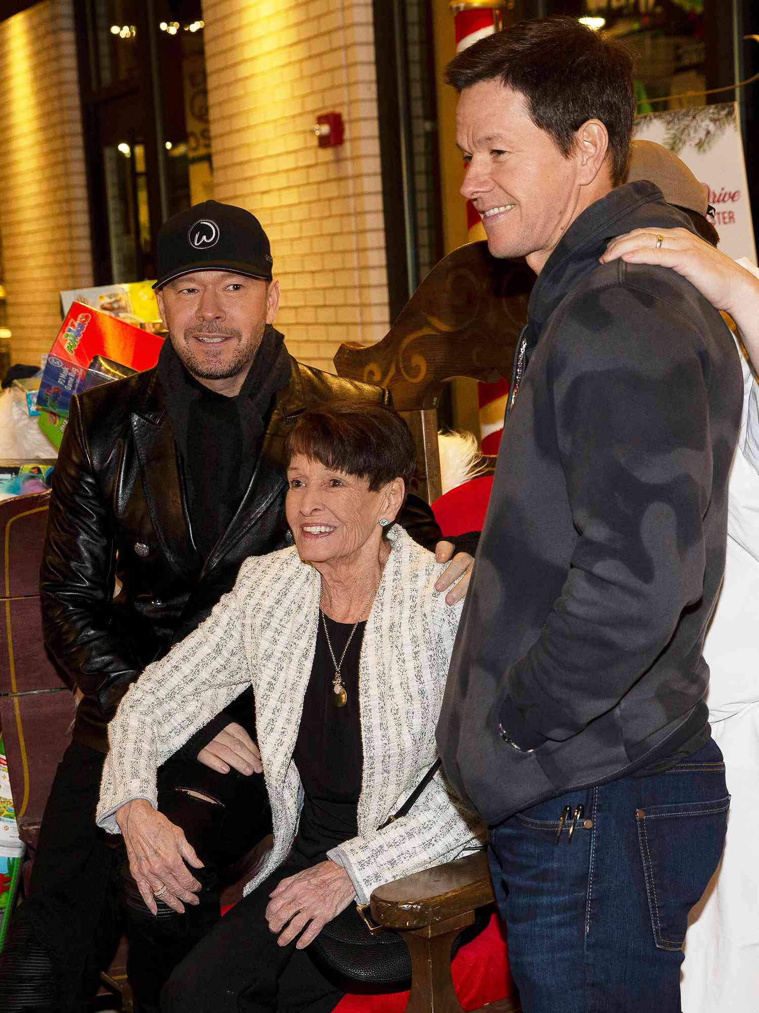 Donnie and Mark Wahlberg pose with their mother Alma, as they attend the grand opening of the newest location of the family restaurant, Wahlburgers, in their childhood neighborhood of Dorcester in Boston, Massachusetts on December 18, 2018.