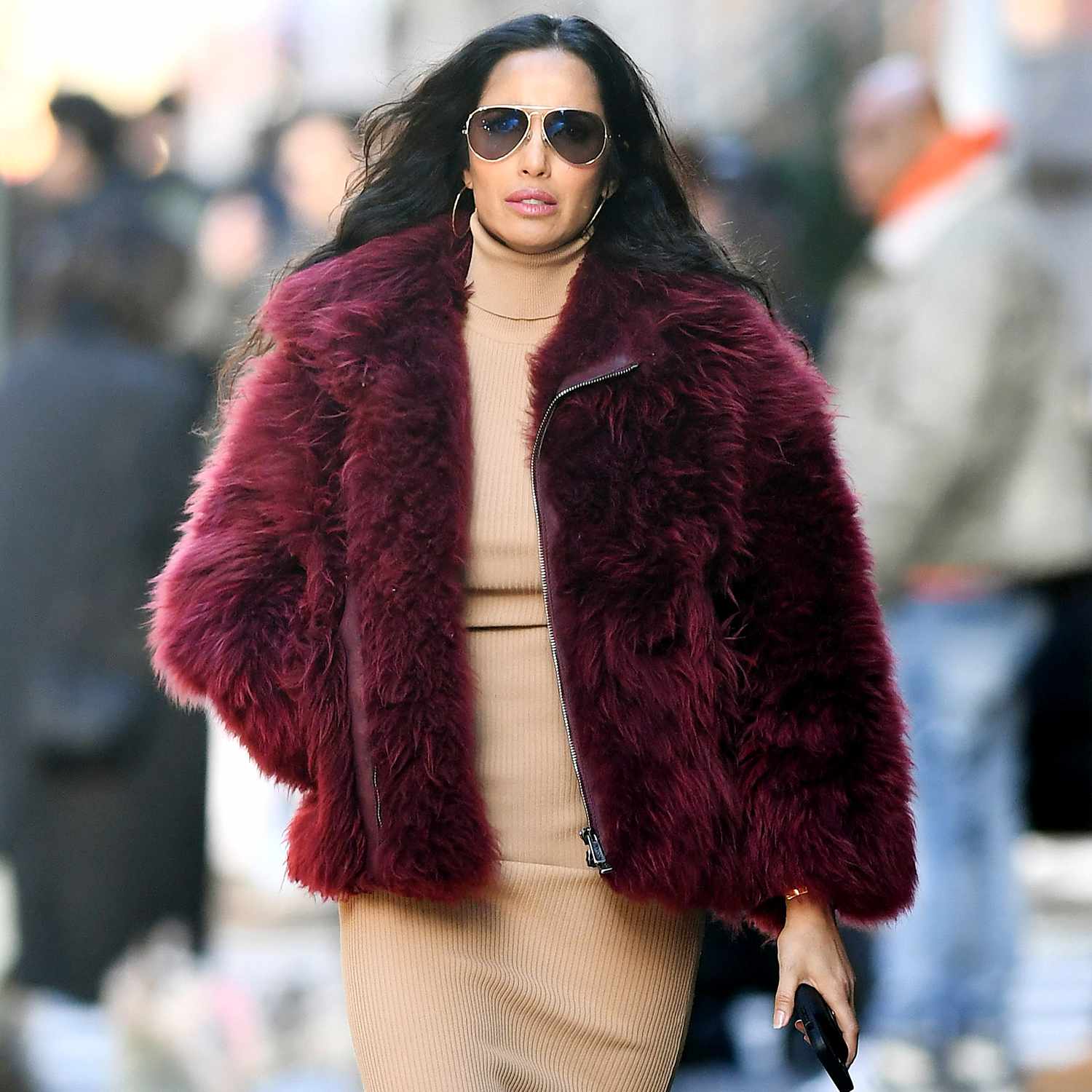 Padma Lakshmi looks fashionable while on a stroll in New York City. The 54 year old model wore a burgundy jacket, matching boots, and a beige dress.