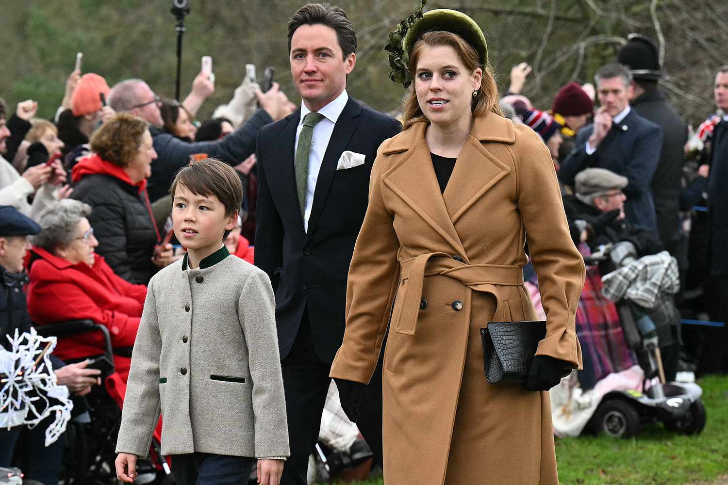 Britain's Princess Beatrice of York and her husband Edoardo Mapelli Mozzi walk with his son Christopher Woolf upon arrival to attend the Royal Family's traditional Christmas Day service at St Mary Magdalene Church in Sandringham