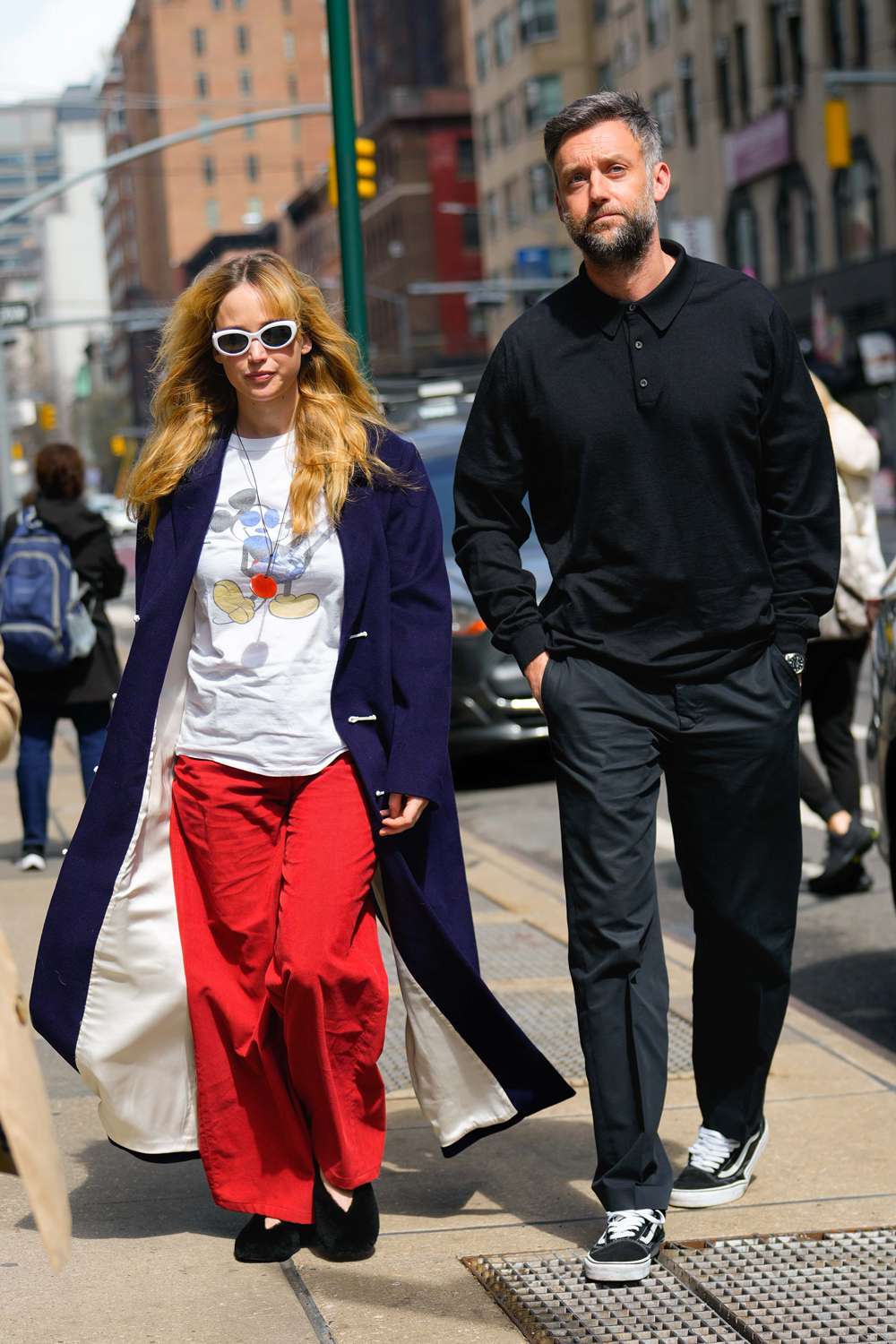  Jennifer Lawrence and Cooke Maroney step out together in New York City. The American actress carried a red hermes bag and wore a blue trench coat, vintage Mickey Mouse t-shirt, red trousers, and black flats.